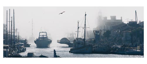 Le Grau du Roi, Le canal et le vieux phare sous la brume. Carte postale panoramique 10x23 cm. Photographe: Marianne Raous