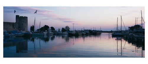 Aigues Mortes - Photographie couleur - Les remparts vus depuis le port à la fin du jour- Carte Postale panoramique 10x23. Photographe Marianne Raous